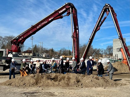 We broke ground on the Amplify GR F3 project on a beautiful, sunny March day last week. Image of 2 cranes and a group of people with hard hats and shovels