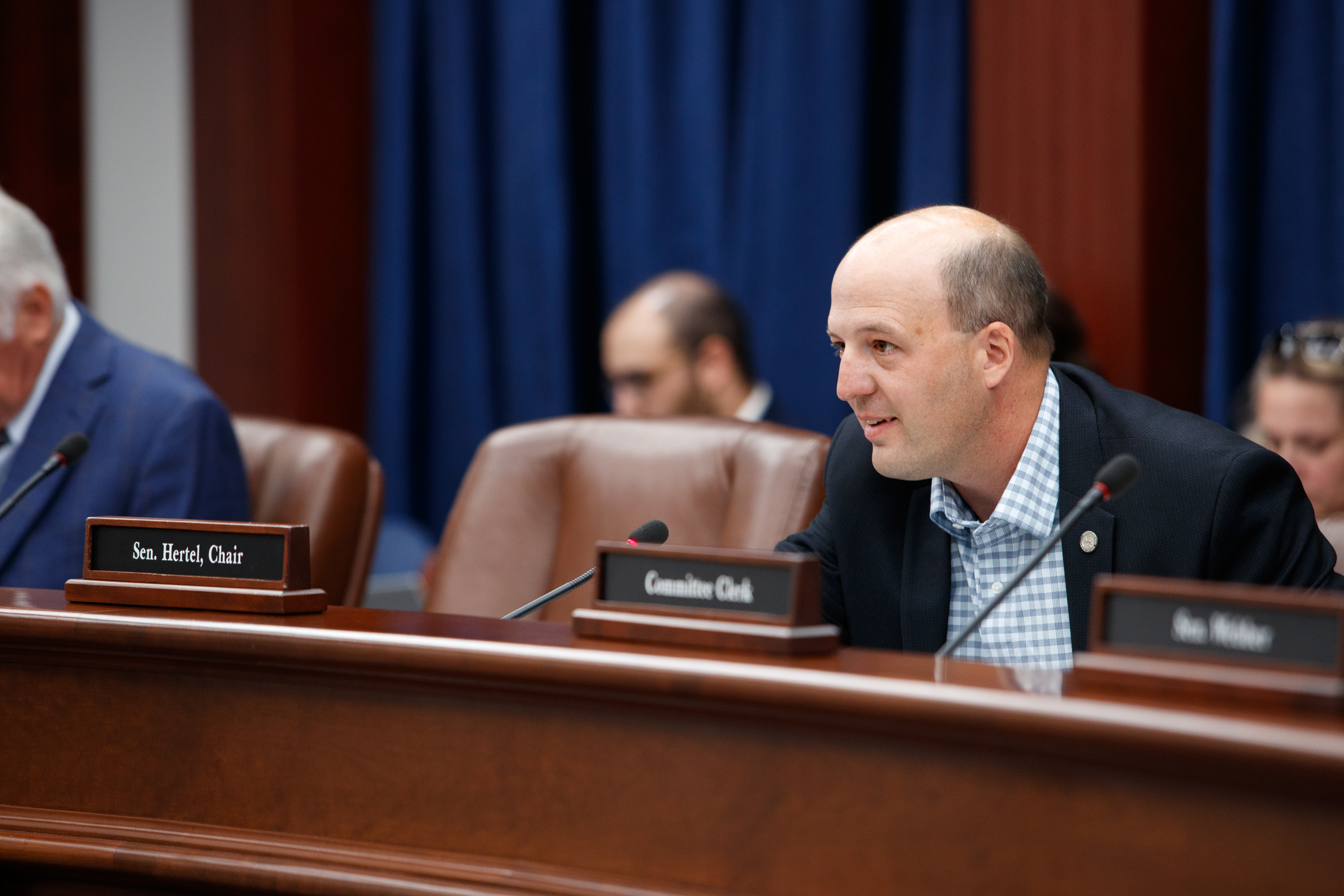 Senator Hertel speaks into the microphone as he chairs the Senate Committee on Energy and Environment