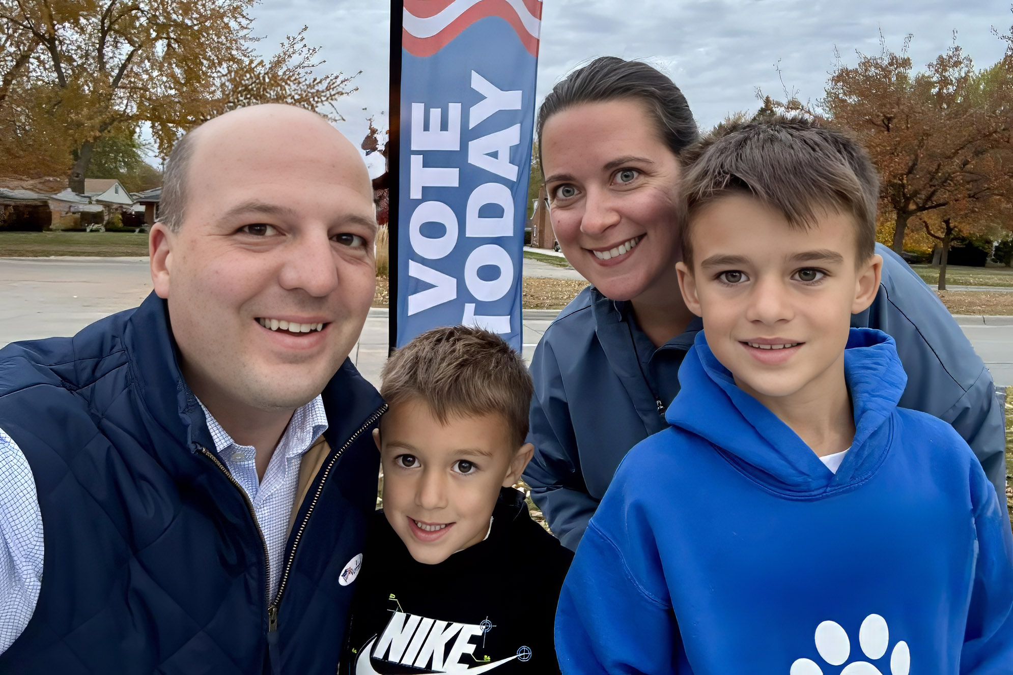 Senator Hertel and family posing in front of a Vote Today sign