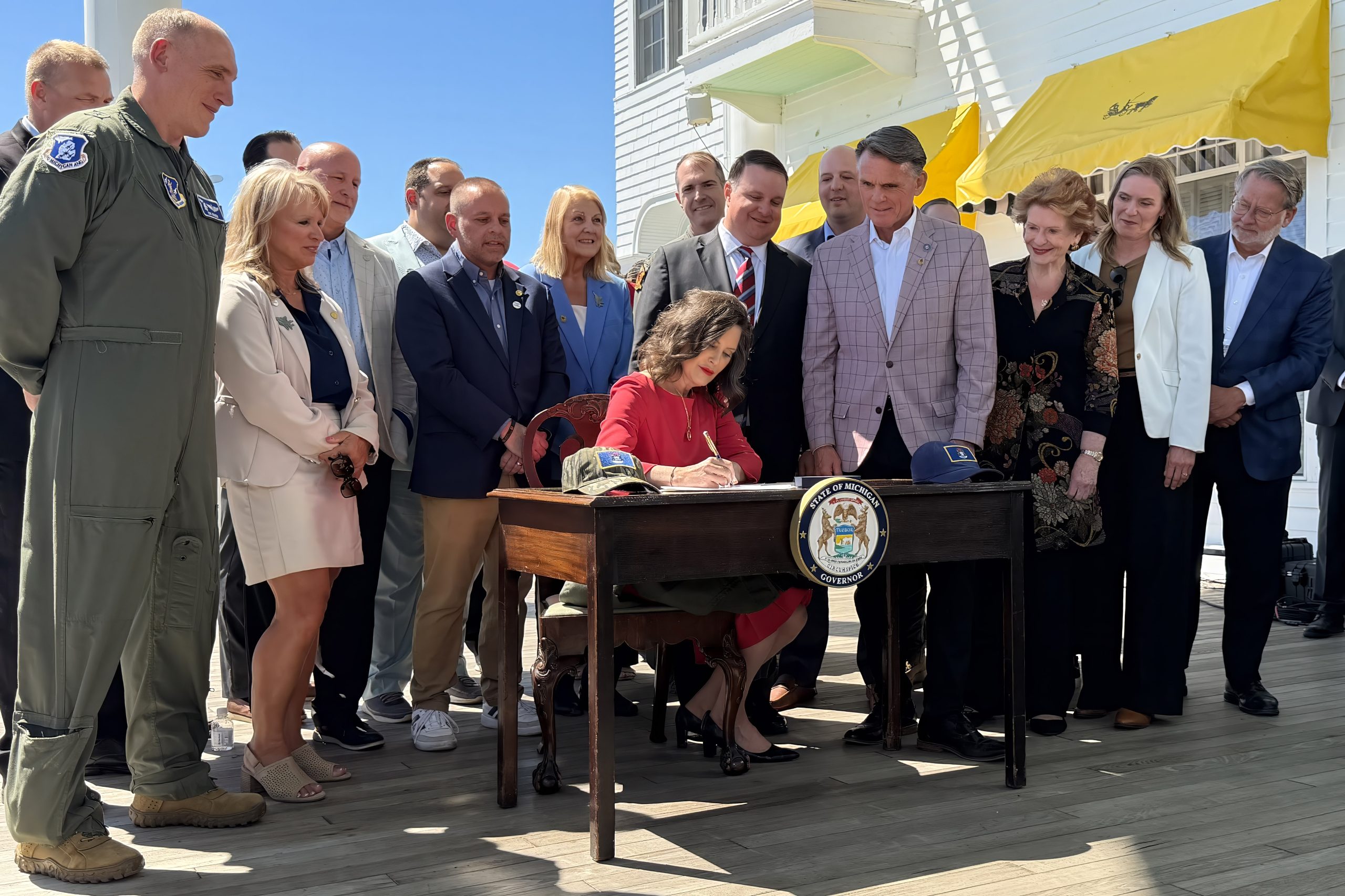 Governor Whitmer signing the Selfridge funding bill surrounded by legislators