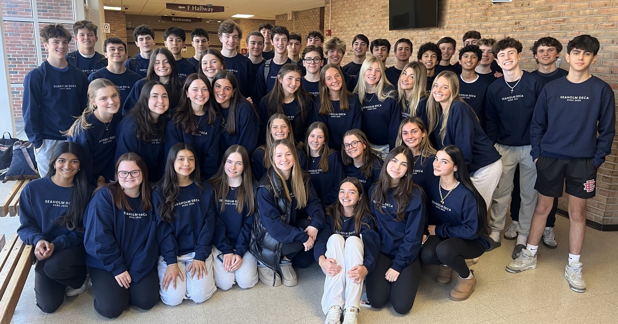 Seaholm High School DECA qualifiers. A group of highschoolers posing together wearing matching navy crew necks