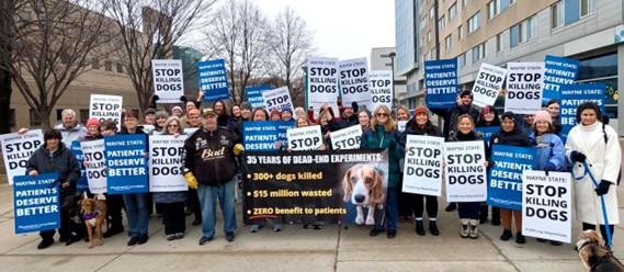Senator Polehanki standing with  a large group of protestors holding signs reading "Stop Killing Dogs"