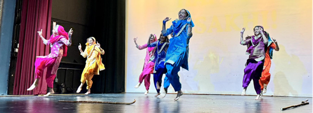 A group of girls dancing on stage to celebrate Sikh