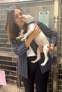 Sen Polehanki holding a puppy. The puppy is licking her face