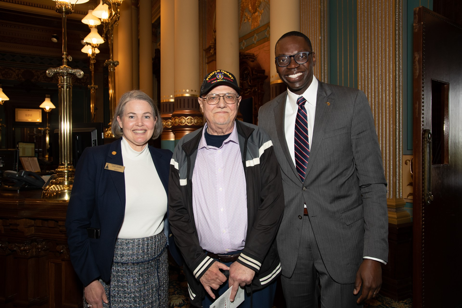 Potential Caption: Sen. Sue Shink (D-Northfield Twp.), Sen. Shink's guest, Navy Vietnam Veteran and Jackson County resident Donald Bliss, and Lt. Gov. Garlin Gilchrist II are pictured on the Senate floor following the Michigan Senate's 28th Annual Memorial Day Ceremony on Thursday, May 25, 2023.