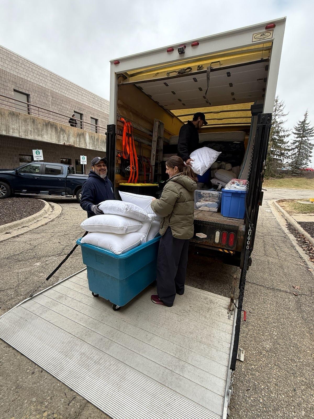 People unloading a truck of house supplies for Reed Manor