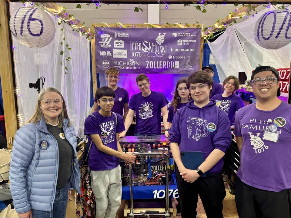 Senator Shink at First Robotics with a group of highschool students psoing in front of a robot