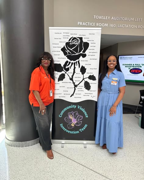 Team Shink's Constituent Services Director, Sydney at the 4th Annual Community Violence Intervention Summit posing in front of a sign with a black rose